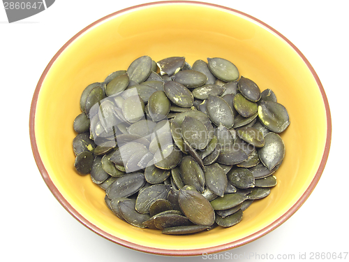 Image of Pumpkin seeds in bowl of ceramic on white background