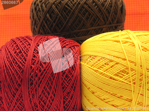 Image of Three  balls of wool  in yellow, brown and red