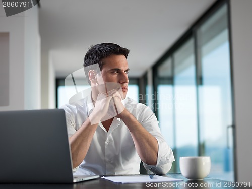 Image of business man working on laptop computer at home