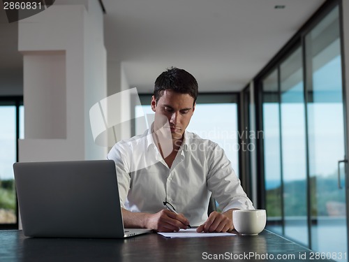 Image of business man working on laptop computer at home