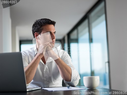 Image of business man working on laptop computer at home