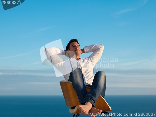 Image of relaxed young man at home on balcony