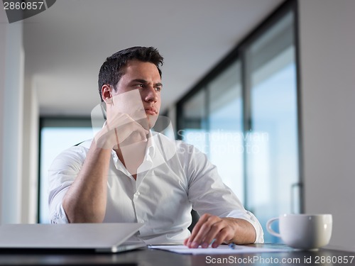Image of business man working on laptop computer at home