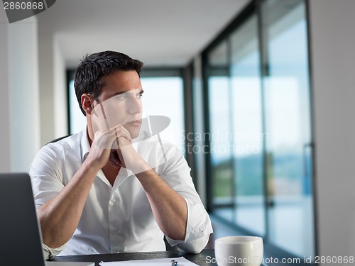 Image of business man working on laptop computer at home