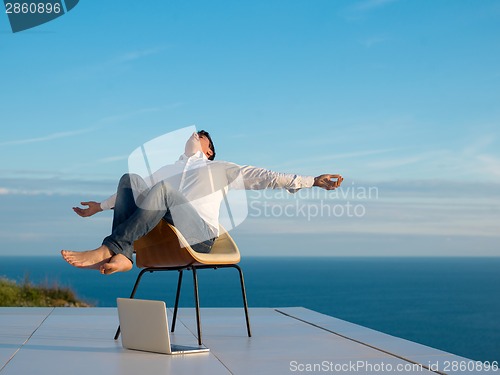 Image of relaxed young man at home on balcony