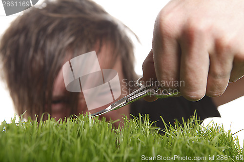 Image of Young man cuts English lawn 