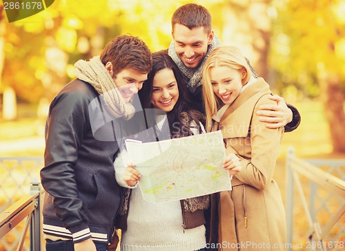 Image of couples with tourist map in autumn park