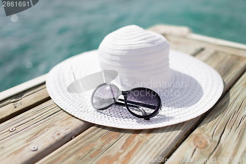 Image of close up of hat and sunglasses at seaside