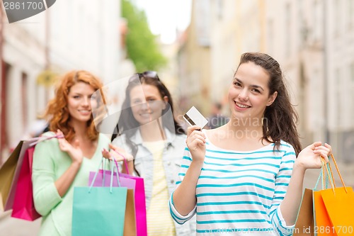 Image of smiling teenage girls with shopping bags on street