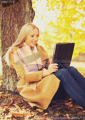 Image of woman with tablet pc in autumn park