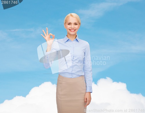 Image of smiling businesswoman showing ok-sign with hand