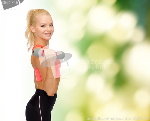 Image of smiling beautiful sporty woman with dumbbell