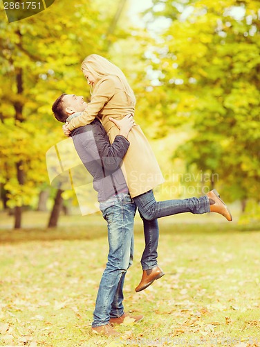 Image of romantic couple playing in the autumn park