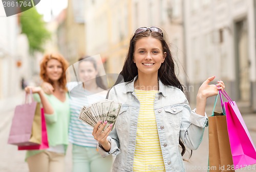 Image of smiling teenage girls with shopping bags on street