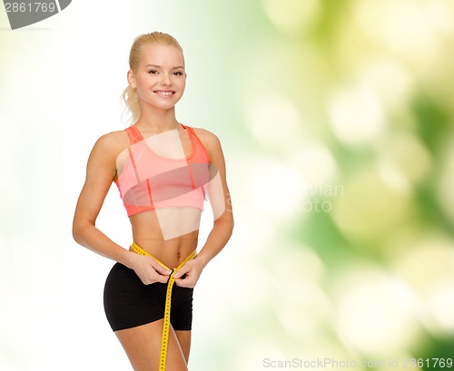 Image of smiling sporty woman with measuring tape