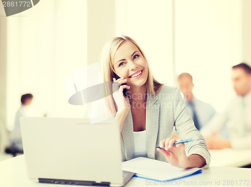 Image of businesswoman with phone in office