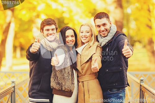 Image of group of friends having fun in autumn park