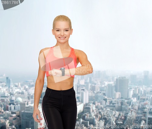 Image of smiling woman with heart rate monitor on hand