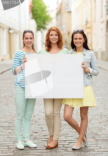 Image of smiling teenage girls with blank billboard