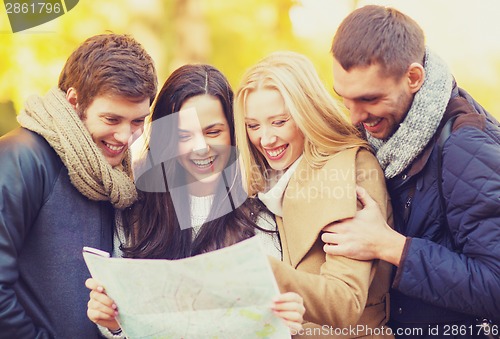 Image of couples with tourist map in autumn park