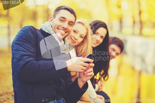 Image of group of friends having fun in autumn park