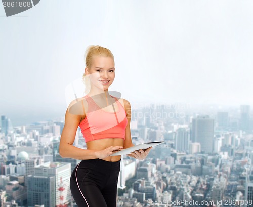 Image of smiling sporty woman with tablet pc computer