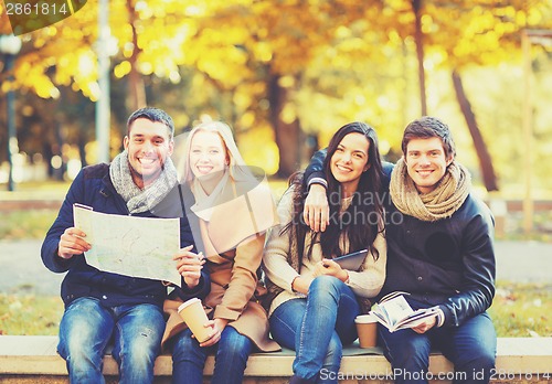 Image of couples with tourist map in autumn park