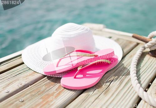 Image of close up of hat and slippers at seaside