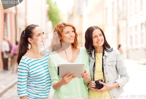 Image of smiling teenage girls with tablet pc and camera