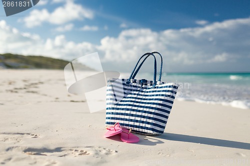 Image of close up of beach bag and slippers at seaside
