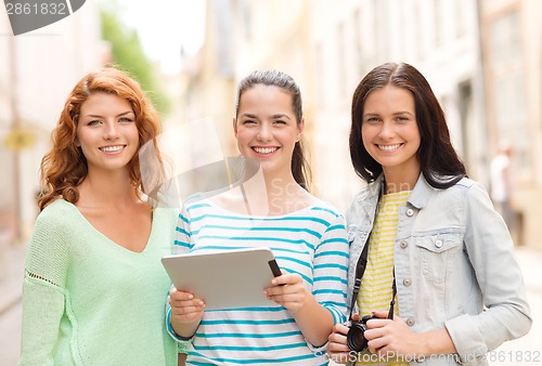 Image of smiling teenage girls with tablet pc and camera