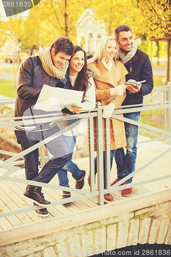 Image of couples with tourist map in autumn park