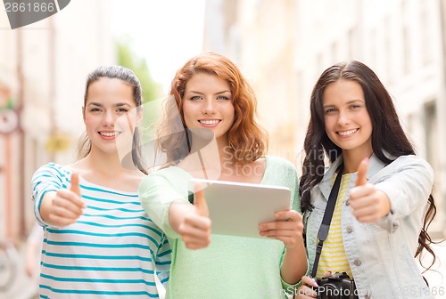 Image of smiling teenage girls with tablet pc and camera