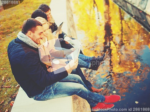 Image of couples with tourist map in autumn park