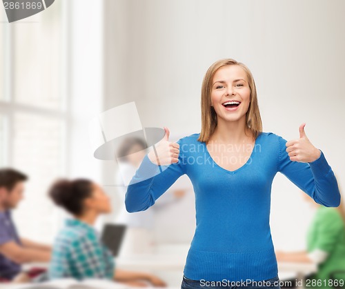 Image of smiling girl in casual clothes showing thumbs up