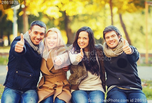 Image of group of friends having fun in autumn park