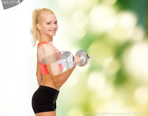 Image of young sporty woman with heavy steel dumbbell