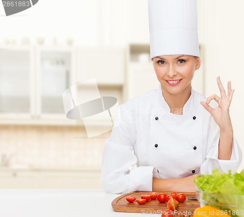 Image of female chef with vegetables showing ok sign