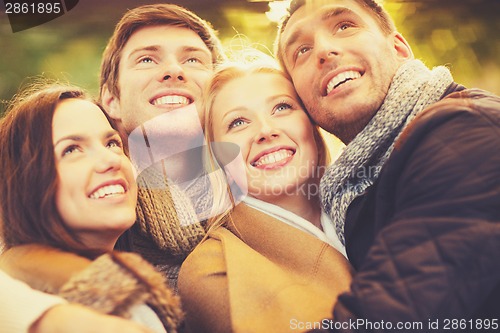 Image of group of friends having fun in autumn park