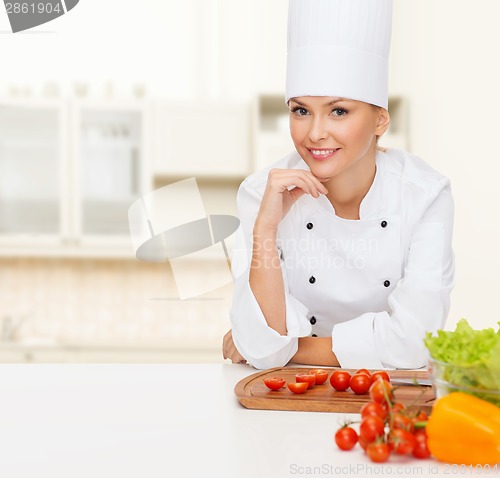 Image of smiling female chef with vegetables