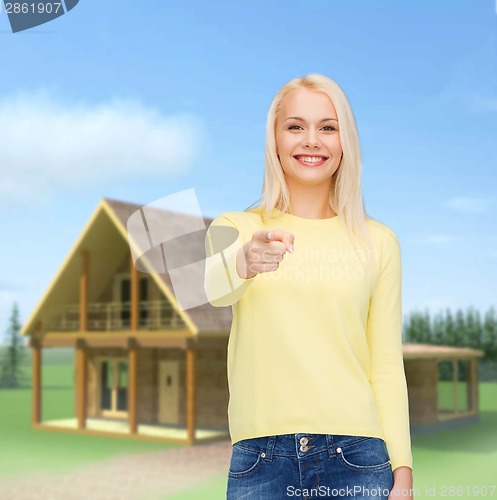 Image of smiling woman pointing finger at you