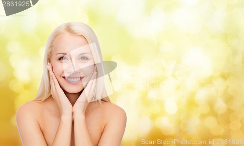 Image of beautiful woman touching her face skin