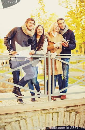 Image of couples with tourist map in autumn park