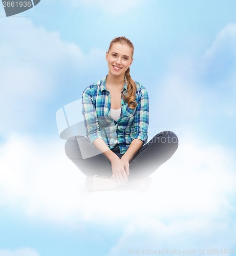 Image of young woman in casual clothes sitting on floor