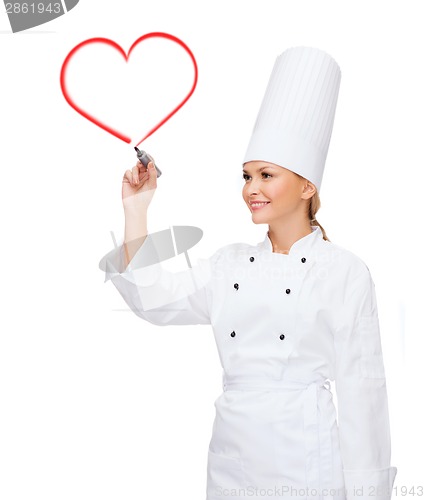 Image of smiling female chef writing something on air