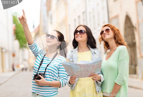 Image of smiling teenage girls with map and camera