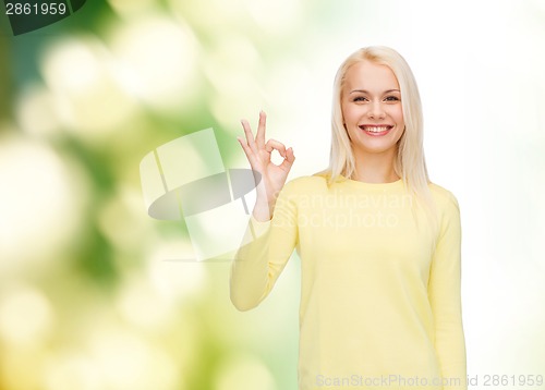 Image of young businesswoman showing ok sign