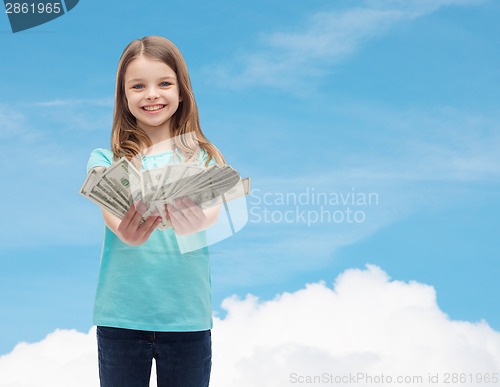 Image of smiling little girl giving dollar cash money