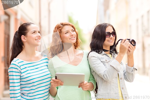 Image of smiling teenage girls with tablet pc and camera