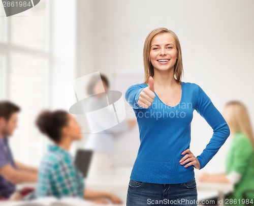 Image of smiling girl in casual clothes showing thumbs up